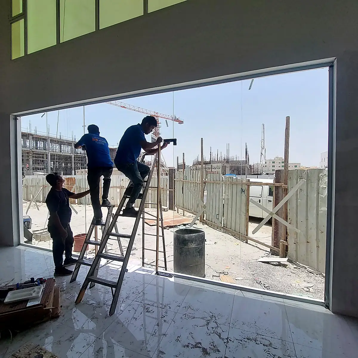 Glaziers installing a glass shopfront at dusk