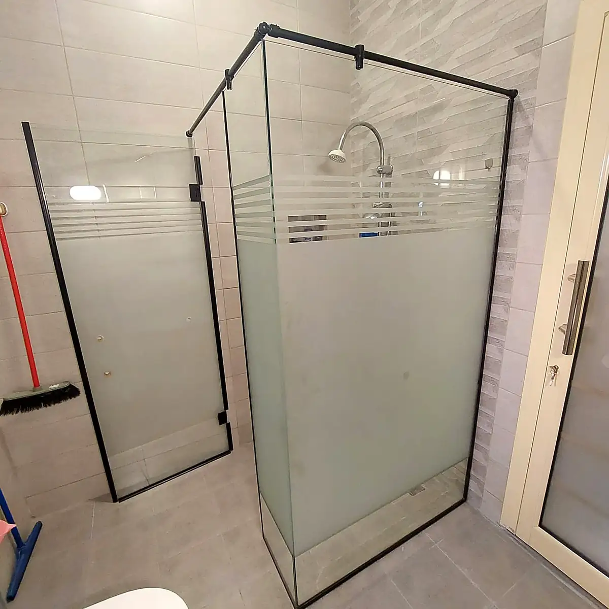 Frameless glass shower enclosure in a tiled bathroom
